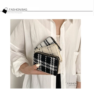 Close-up of small tweed zipper purses with plaid patterns and gold metal zippers