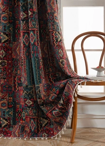 Detail of bohemian geometric jacquard curtain fabric with off-white tassels and heavy texture