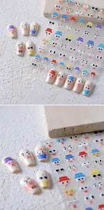 Macro detail of cartoon facial expression nail art stickers on long white manicure tips