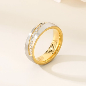 Close-up of dual-tone stainless steel ring with brushed finish and inlaid pavé crystals