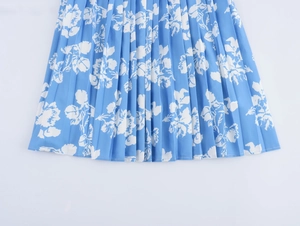 Detailansicht des Plissee-Blumenmusters und des leichten blauen Stoffes dieses eleganten Kleides
