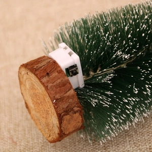 Close-up of the wooden base and electronic light switch of a snowy cedar Christmas tree