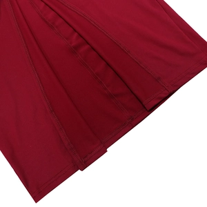 Detailed close-up of dark red fabric showing fine stitching and smooth ruched texture