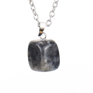 Macro shot of gray natural raw stone pendant necklace with irregular mineral texture