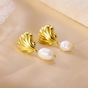 French style gold shell earrings with white oval pearls on elegant beige silk fabric