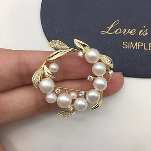 Detail of a gold floral brooch with natural freshwater pearls and sparkling crystals