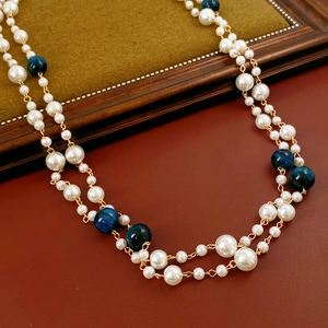 Detail of elegant double-layered necklace with white pearls and blue tiger eye stone beads