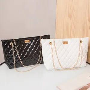 Quilted faux leather tote bags in black and white with gold chain straps and turn-lock