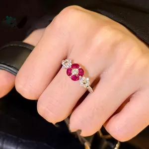 Macro detail of bouquet ring with ruby red oval stones and white zircon accents