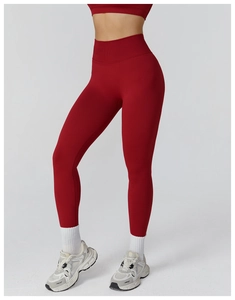 Macro shot of high-waist seamless compression yoga leggings in deep red matte fabric