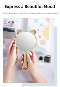 Macro shot of handheld wooden makeup mirror with cute bear ears and cat paw handle detail