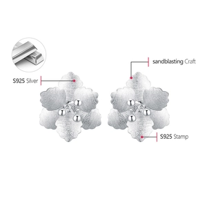 Macro view of S925 silver flower stud earrings with sandblasting craft and stamp