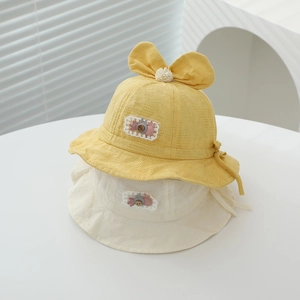 Close-up of baby sun hat with cute rabbit patch, lace edges, and decorative bow detail