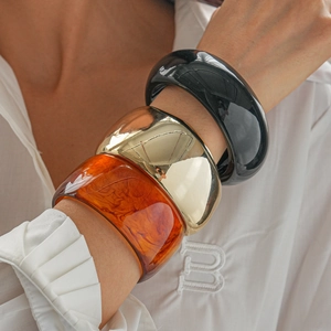Three-piece set of wide resin and gold metal geometric bracelets in a retro style