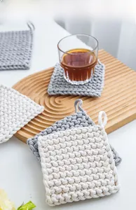 Detail of woven cotton heat resistant mats with portable hanging loops in neutral colors