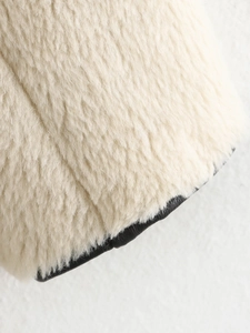 Close-up of cream faux fur fabric with premium black leather trim edge detail