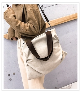 Vue détaillée d'un grand sac cabas en toile crème avec des bretelles marron contrastées