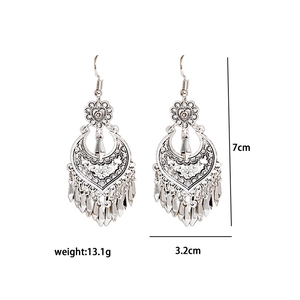 Detail view of ethnic metal tassel earrings with 7cm length and 3.2cm width measurements