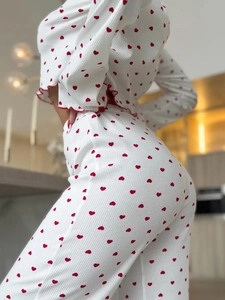 Detail of red heart prints on ribbed knit fabric with delicate ruffled lettuce hem edges
