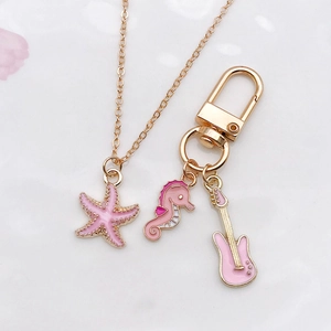 Pink enamel starfish necklace and seahorse guitar charms on a gold chain