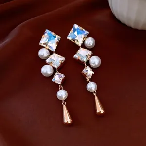 Vintage gold drop earrings with crystals and pearls on elegant brown silk background