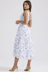 Detail of white midi dress with blue floral print showing pleated hem and A-line silhouette