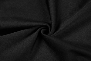 Détail du tissu noir avec plis radiaux sur une robe moulante à manches longues