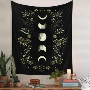 Detail of black bohemian tapestry featuring lunar moon phases and green leaf border
