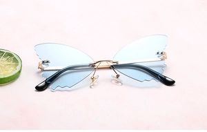 Detail of light blue butterfly rimless sunglasses with gold metal frame and nose pads