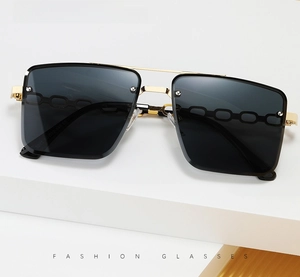 Close-up of golden metal temples and grey lenses on rimless square sunglasses