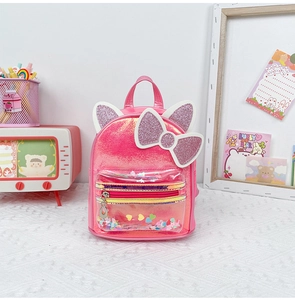 Detail of pink glitter backpack featuring cat ears, large bow, and clear sequin pocket