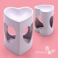 Close-up of white ceramic aroma burner with heart-shaped cutout on a pink background