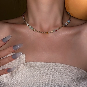 Close-up of baroque freshwater pearl necklace with colorful beads on a model collarbone