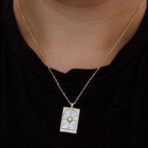 Macro detail of gold vintage tarot necklace featuring The Star shell pendant with CZ
