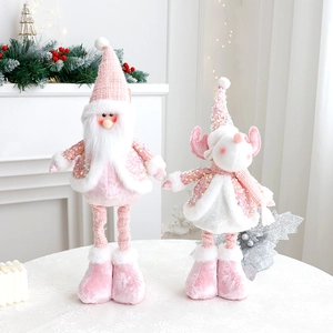 Close-up of pink sequined Santa and reindeer plush dolls on a white festive mantle