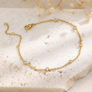 Vue détaillée du bracelet en acier doré avec six zircons sertis clos élégants