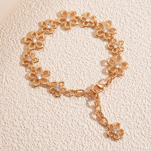 Gold floral bracelet with hollow flower links and sparkling cubic zirconia centers