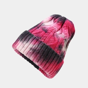 Close-up of the thick cable knit texture and tie-dye color gradient on the warm winter hat