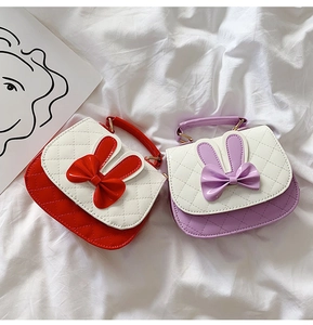 Detail of cute rabbit ear handbags with bowknot and quilted pattern for girls
