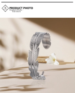 Detailed macro view of vintage silver feather cuff bracelet with intricate metal textures