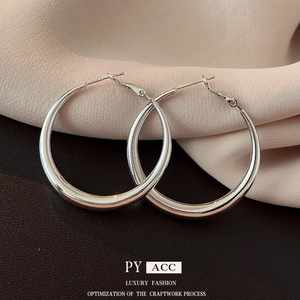 Minimalist silver geometric hoop earrings with polished mirror finish on luxury leather