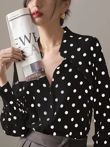 Detailed view of women's black and white polka dot chiffon shirt with elegant V-neckline