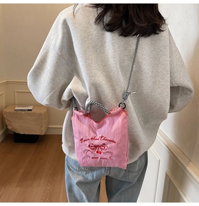 Detail of pink nylon shoulder bag with cherry embroidery and checkered crossbody strap