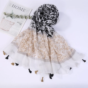 Detail of floral patterns and two-tone fringe tassels on long beach shawl wrap
