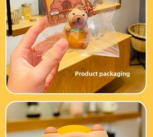 Capybara keychain with yellow fruit accessory in clear packaging and paper backcard