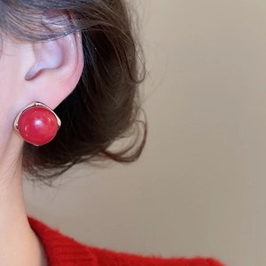 Close-up of a red round bead stud earring on a model's ear with high-quality metal base
