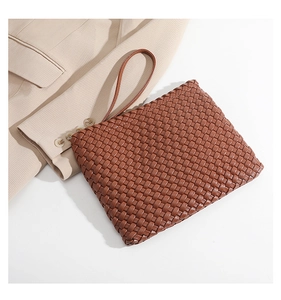 Detailed close-up of premium brown woven leather texture on a stylish clutch bag
