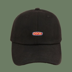 Close-up of black baseball cap with retro GOOD embroidered patch and cotton twill texture