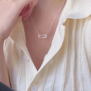 Close-up of 925 sterling silver safety pin necklace with zircon pavé on a model