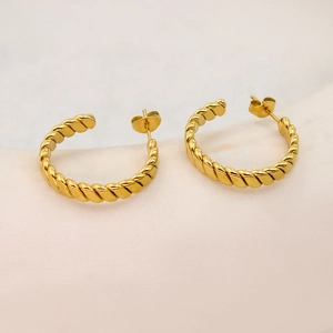 Detailed macro view of 18K gold plated twisted rope hoop earrings with a metallic finish